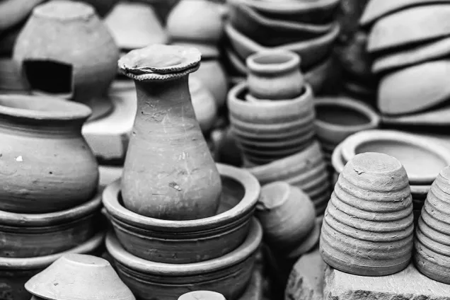 A photo of stacked handmade pottery items in black and white