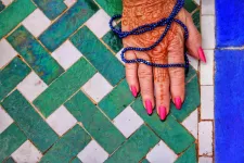 Hands painted with henna holding a mala, Photo: Pixabay